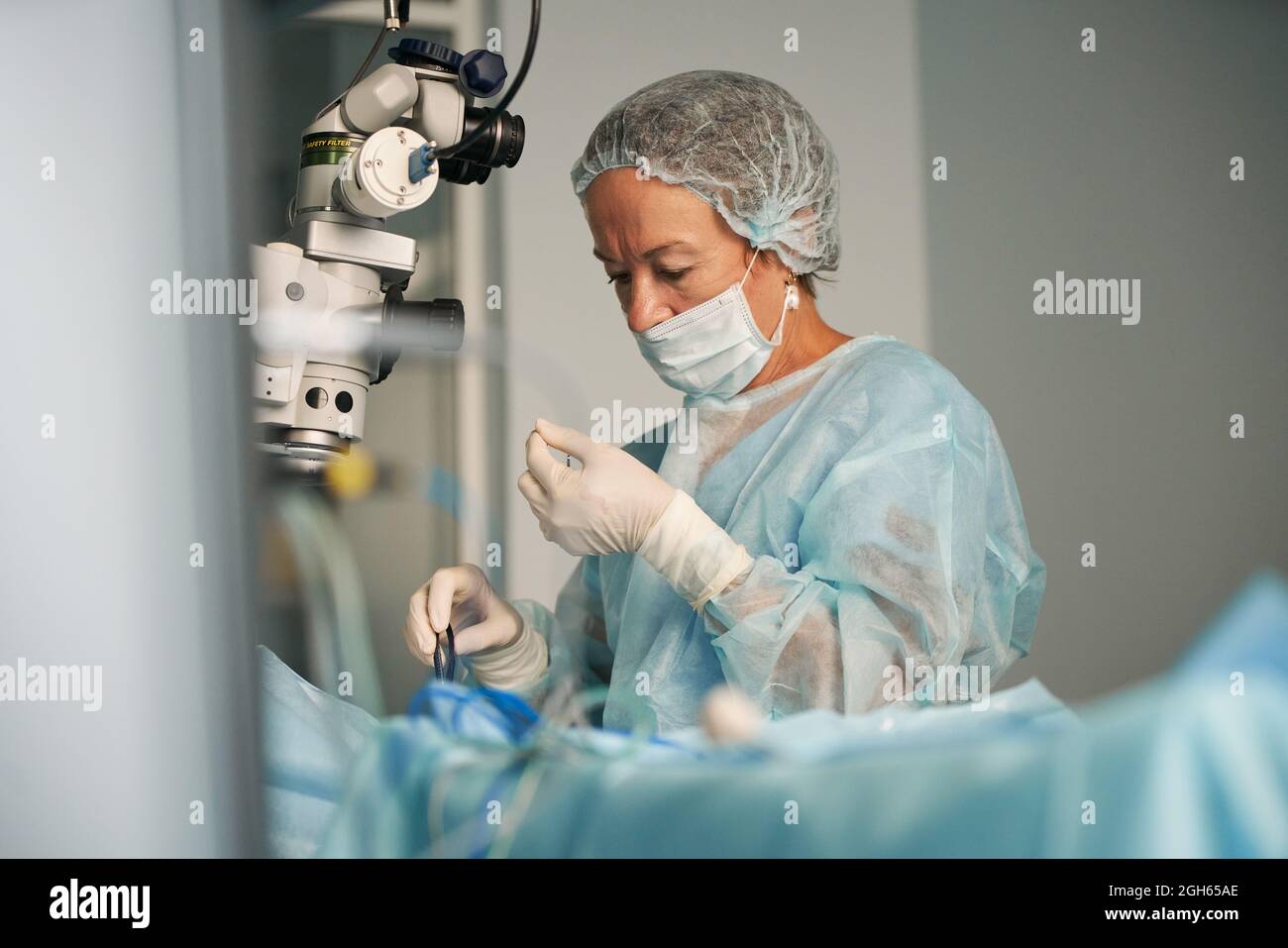 Erwachsene Ärztin in OP-Uniform und sterile Maske sitzt in der Klinik Stockfoto