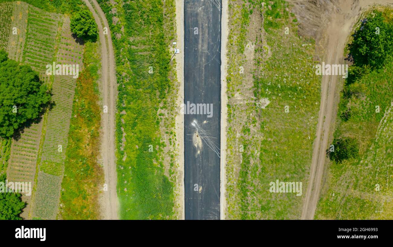Luftaufnahme von einem Asphalt und zwei Landstraßen über grüne Wiese. Stockfoto