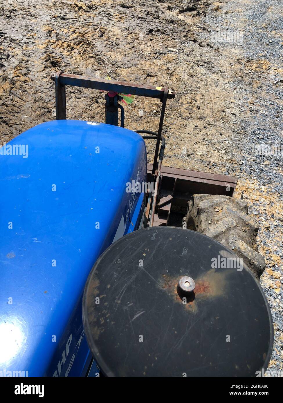 Der Traktor passt den Boden mit dem vorderen Planierraupen mit langsamer Geschwindigkeit über die Vorderansicht von oben an. Stockfoto