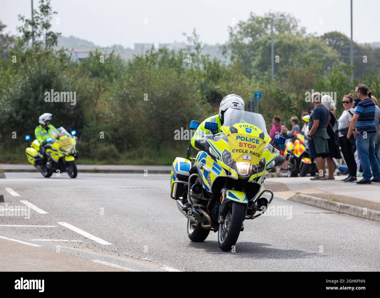 Police Motorräder, die während des Tour of Britain Cycle Race 2021 als rollende Straßensperre fungieren, als es durch Camborne in Cornwall ging. Stockfoto