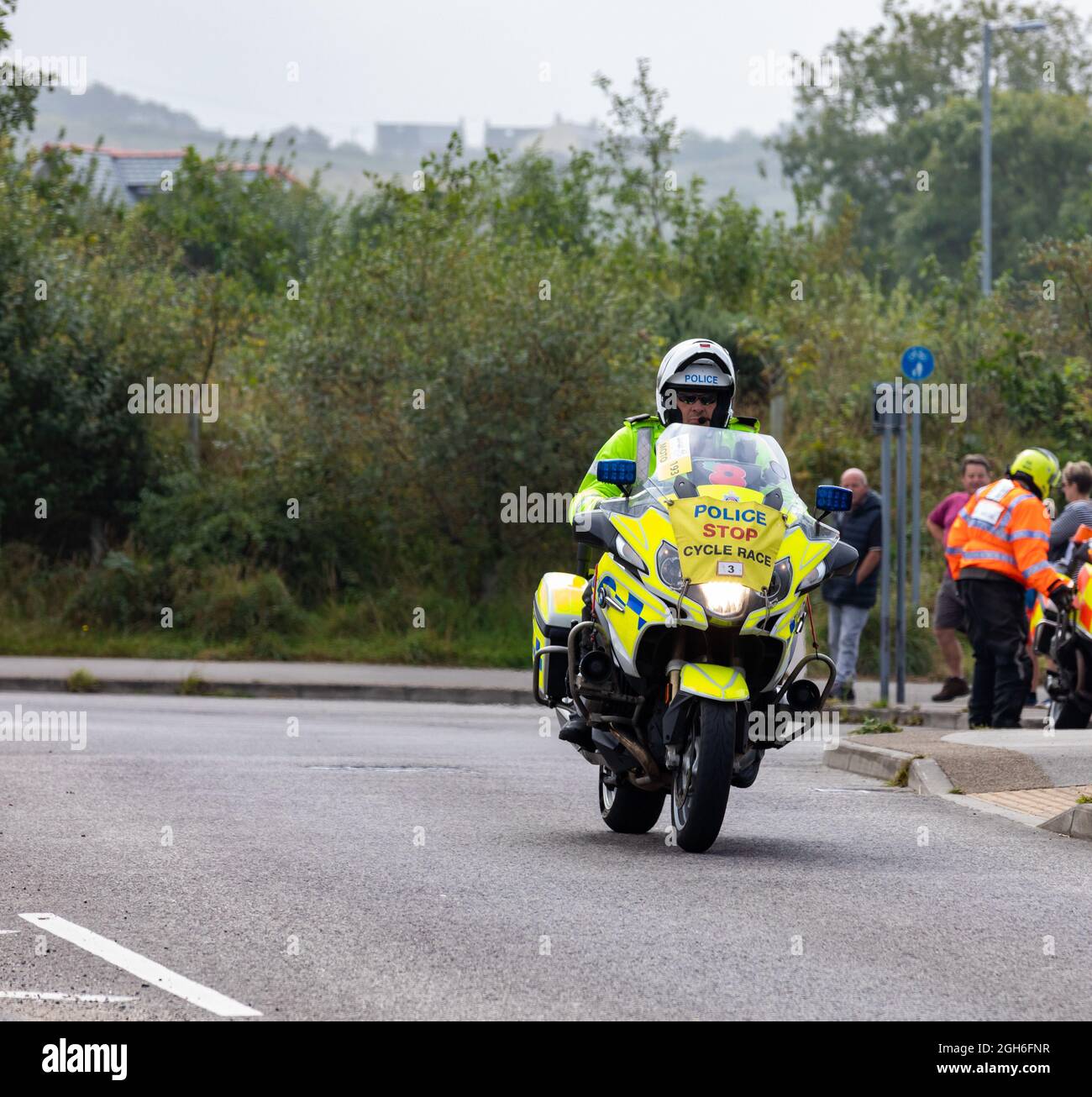 Police Motorräder, die während des Tour of Britain Cycle Race 2021 als rollende Straßensperre fungieren, als es durch Camborne in Cornwall ging. Stockfoto