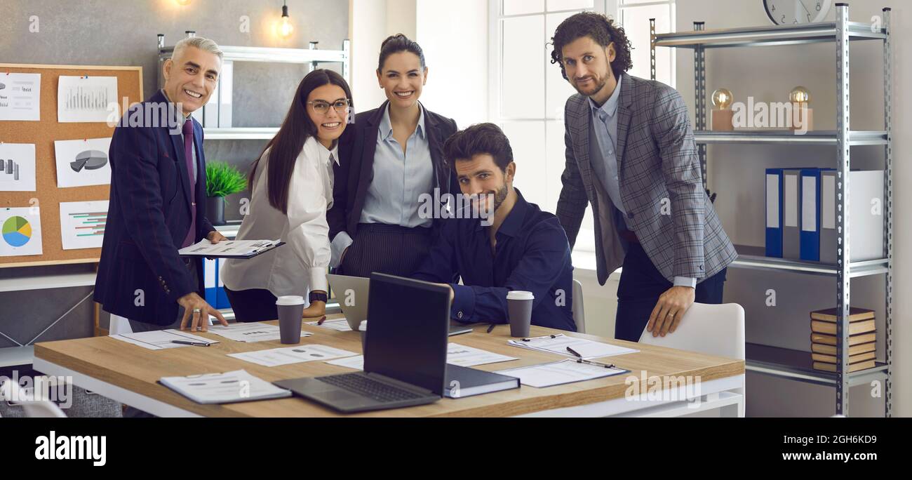 Porträt einer Gruppe lächelnder Kollegen am Arbeitsplatz in einem hellen, modernen Büro. Stockfoto