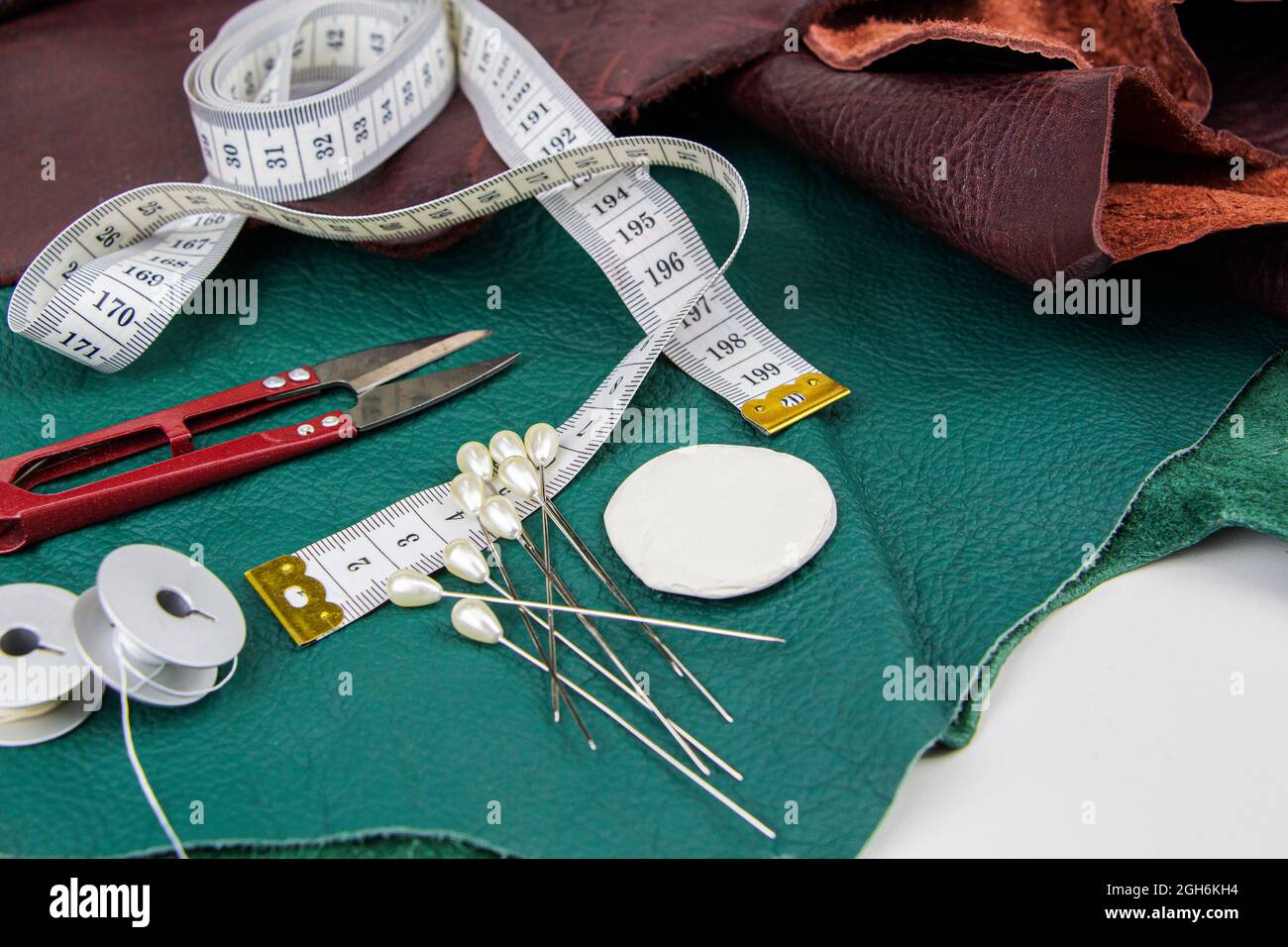 Ein Stück Leder mit Schere, Nadeln, Kreide Stockfoto