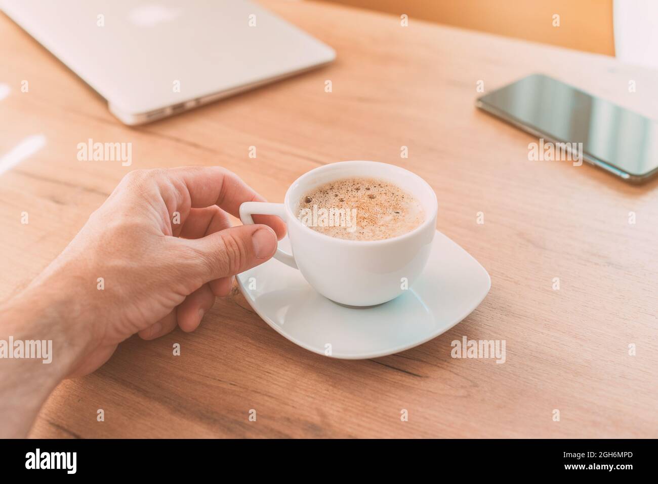 Freiberufler trinkt Kaffee zu Hause im Büro, bevor sie zur Arbeit, Hand halten Tasse, selektive Konzentration Stockfoto