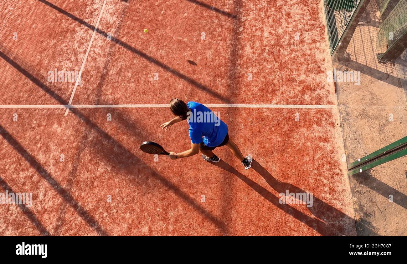 Overhead einer Person, die Paddle-Tennis-Techniken auf einem Tennisplatz im Freien übt. Stockfoto