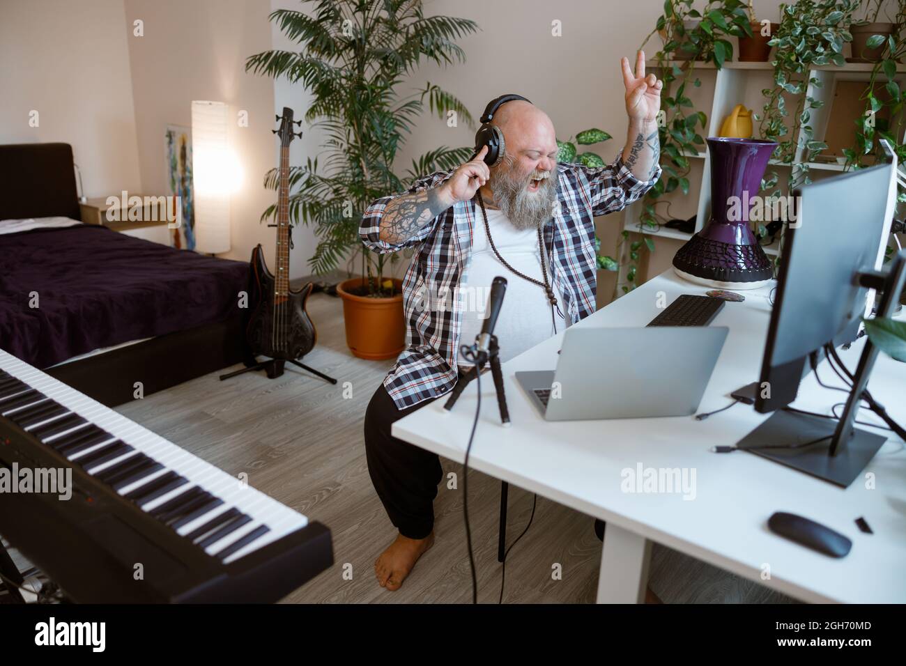 Ein begeisterter, professioneller Moderator führt Podcast durch, in dem Friedensgesten im Heimstudio gezeigt werden Stockfoto