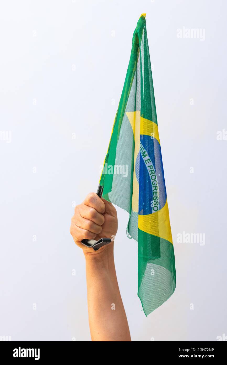 Hält die brasilianische Flagge auf weißem Hintergrund isoliert. Stockfoto