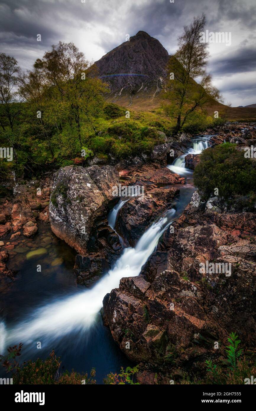 Eine vertikale Aufnahme des Wasserfalls auf dem River Coupall gegen Buachaille Etive Mor in Schottland Stockfoto