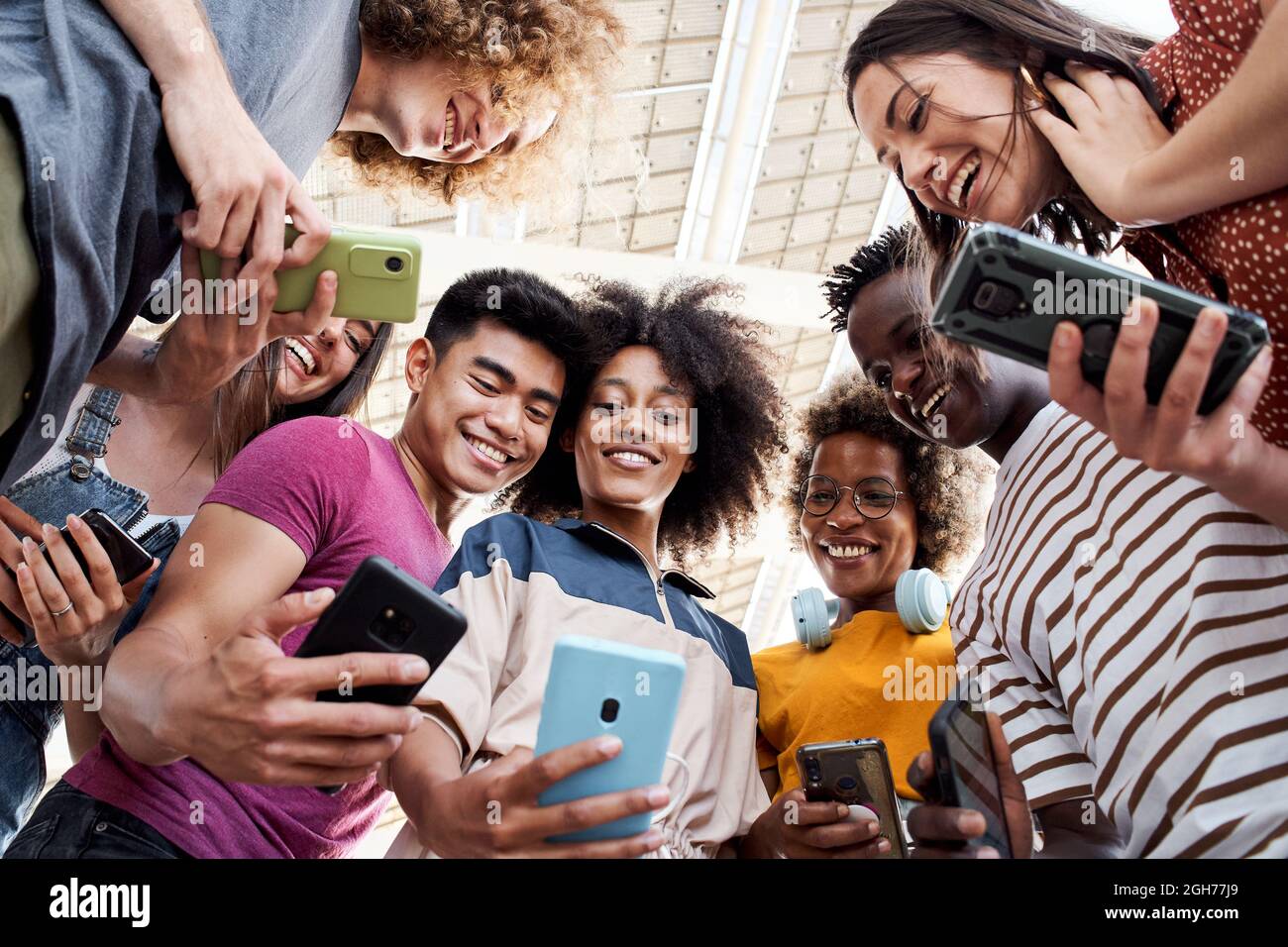 Low-Angle-Ansicht einer Gruppe junger Teenager, die Mobiltelefone halten. Konzept der Technik, Verbindung. Stockfoto