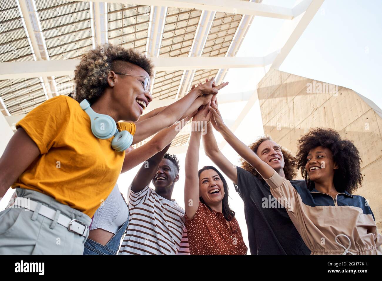 Gruppe junger Menschen, die Hand stapeln. Multiethnische Gruppe von Studenten, die im Freien feiern. Stockfoto