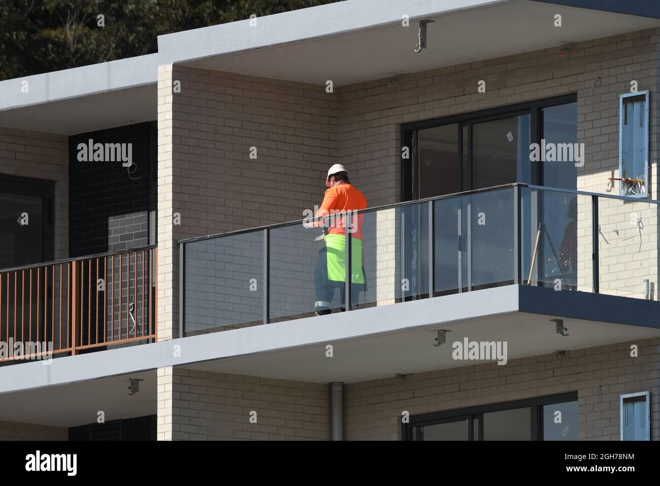 15. Juli 2021. Arbeiter auf dem nun fertiggestellten Balkon in den oberen Stockwerken des neuen sozialen Wohnbaus bei 56-58 Beane St. Gosford, Australien. Teil einer Gebäudekonstruktion Stockfoto