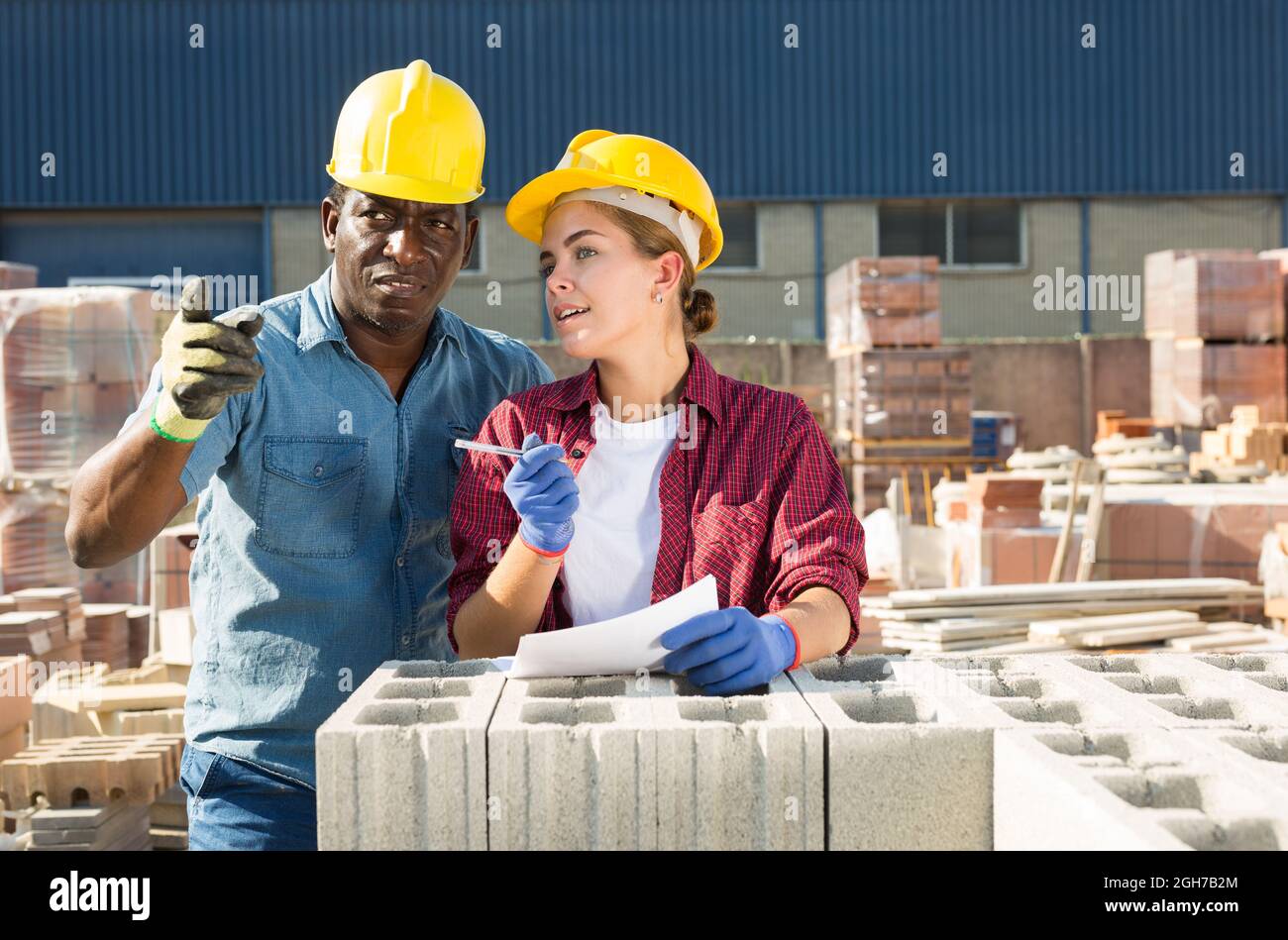 Manager und Arbeiter des Bauladens führen Aufzeichnungen über Ziegelsteine Stockfoto