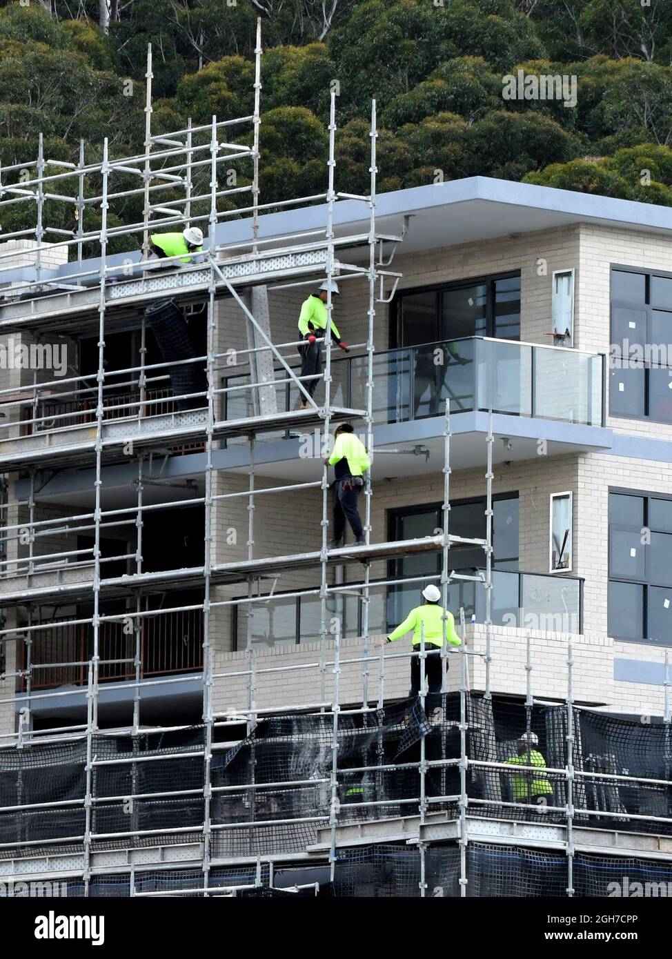 15. Juli 2021. Arbeiter verdecken die Demontage von Sicherheitsnetzen und Gerüsten in den jetzt fertiggestellten oberen Stockwerken des neuen Sozialwohnheimen in der 56-58 Beane St. G. Stockfoto