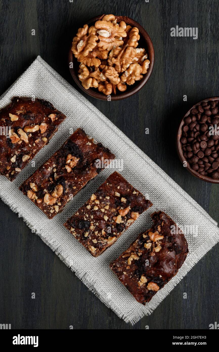 Schokoladenbrownie neben Walnüssen und Pralinen in Tontöpfen Stockfoto
