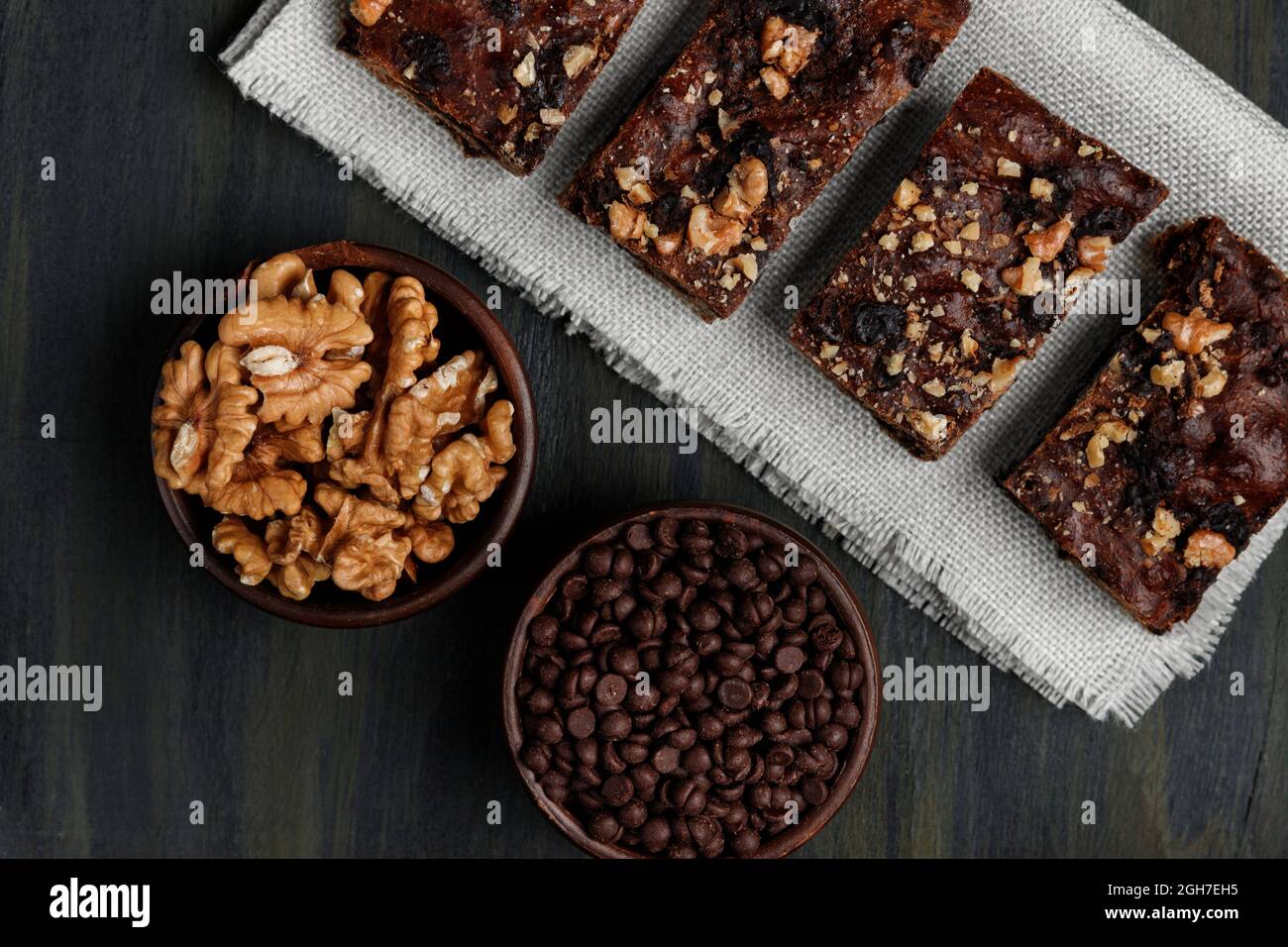 Schokoladenbrownie neben Walnüssen und Pralinen in Tontöpfen Stockfoto