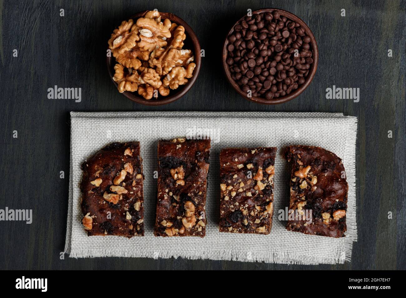 Schokoladenbrownie neben Walnüssen und Pralinen in Tontöpfen Stockfoto