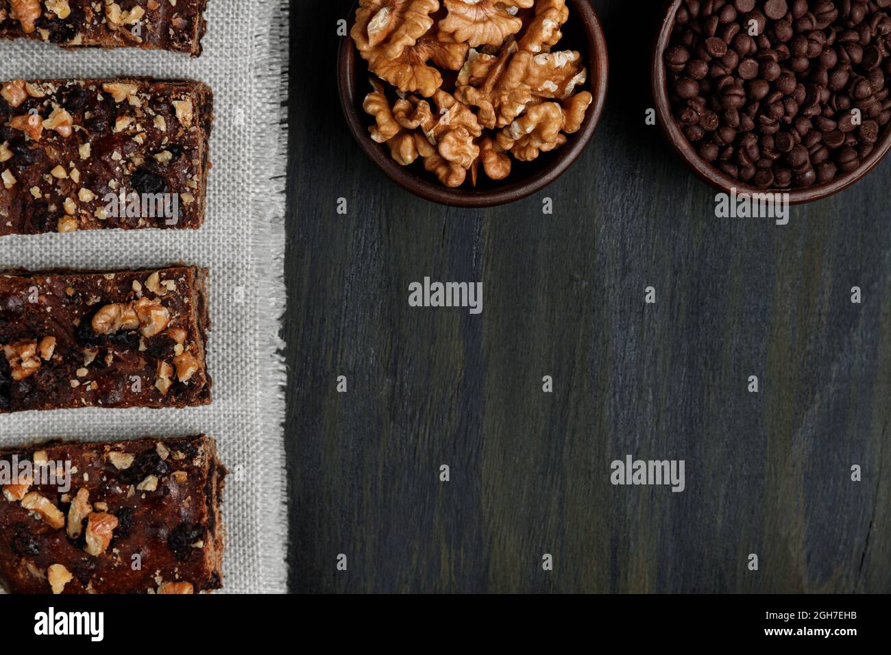 Stücke von Schokolade Brownie neben Walnüssen und Schokolade in Tontöpfen Stockfoto