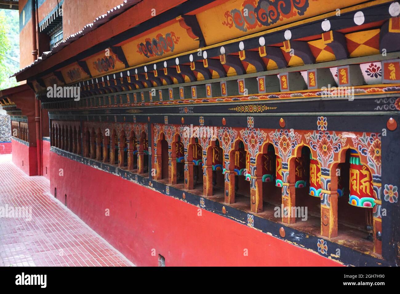 Bunte Gebetsräder säumen eine Wand im Thangtong Dewachen Dupthop Nunnery, Thimphu, Bhutan. Jede Drehung des Rades sendet ein weiteres Gebet himmelwärts. Stockfoto