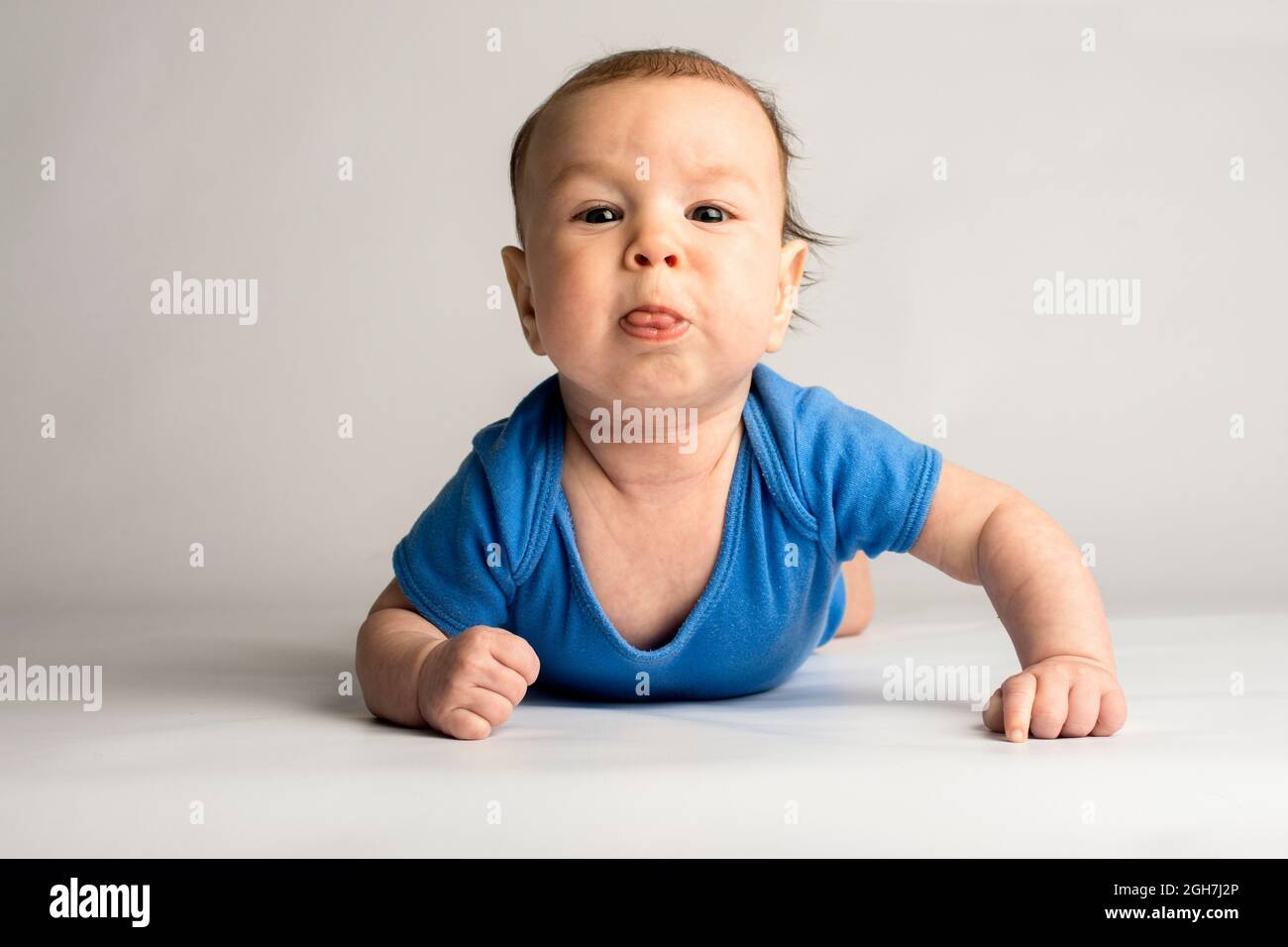 Anspruchsvoll, eigensinnig, stur, Baby. Baby in blauer Kleidung auf weißem Hintergrund. Stockfoto