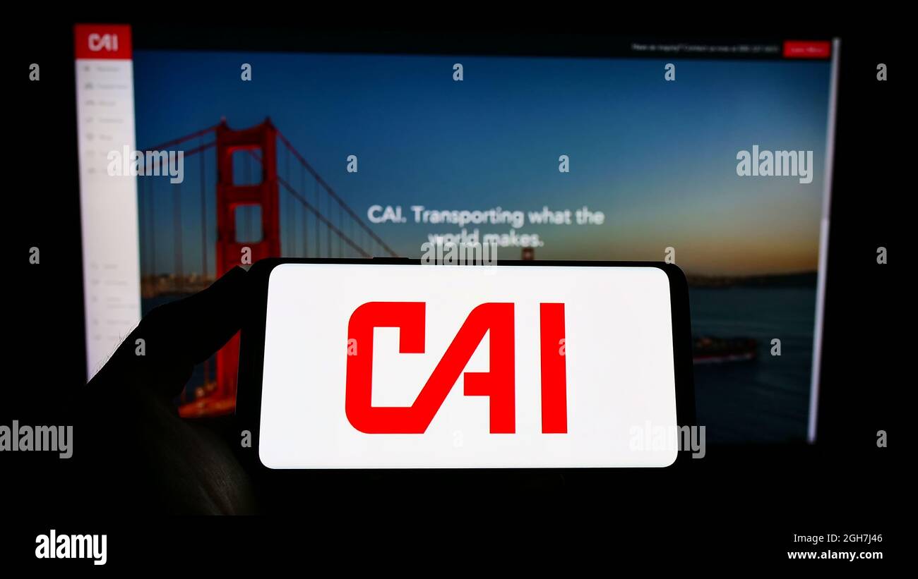 Person, die das Smartphone mit dem Logo des US-Logistikunternehmens CAI International Inc. Auf dem Bildschirm vor der Website hält. Konzentrieren Sie sich auf die Telefonanzeige. Stockfoto