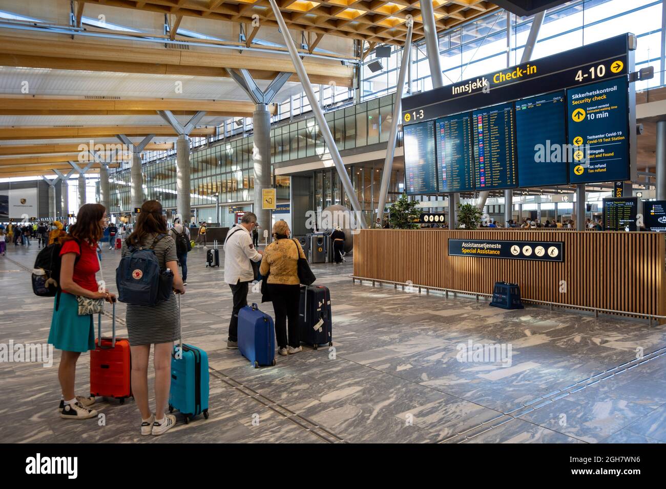 Touristen mit Gepäck sehen auf der Fahrplantafel am Flughafen Oslo Gardermoen in Oslo, Norwegen, Europa Stockfoto