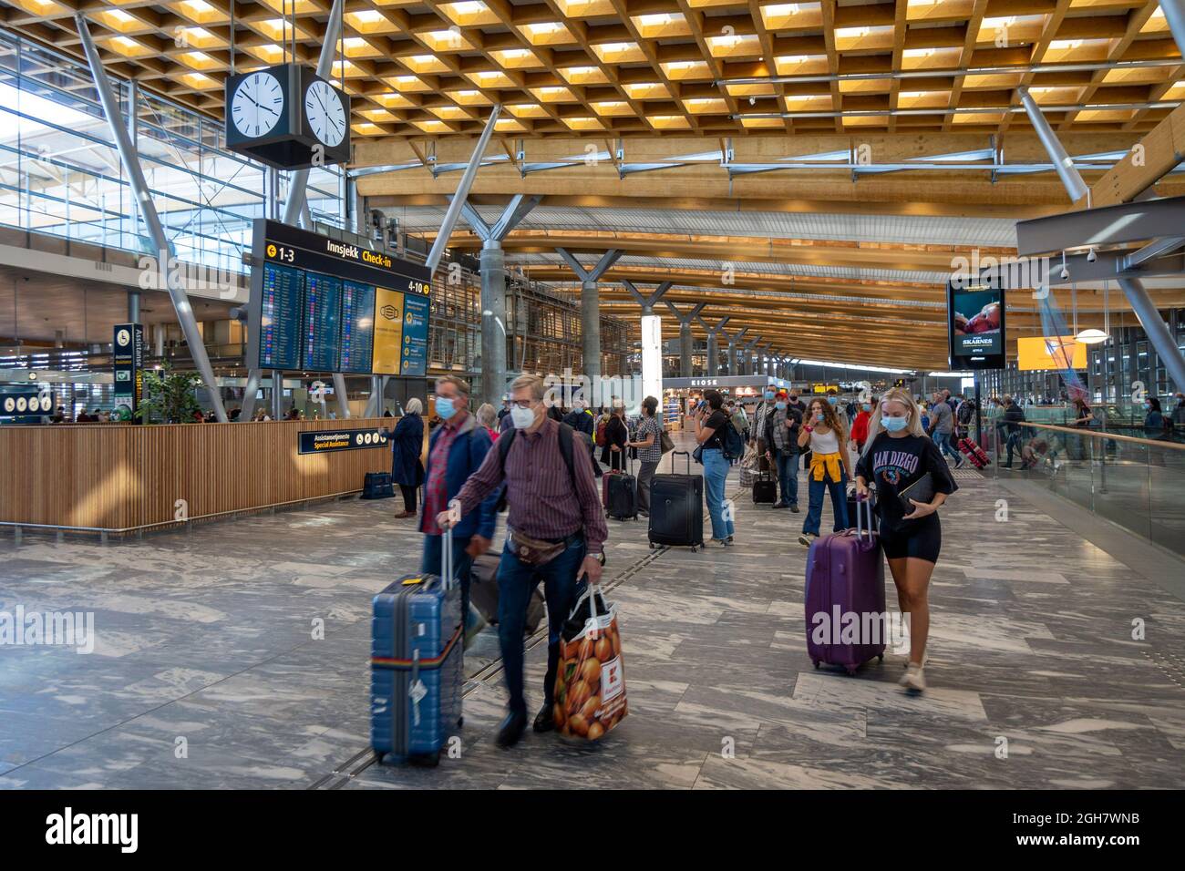 Personen, die Gesichtsmasken tragen, um sich vor Covid-19 zu schützen, während sie durch den Flughafen Oslo Gardermoen in Oslo, Norwegen, Europa reisen Stockfoto