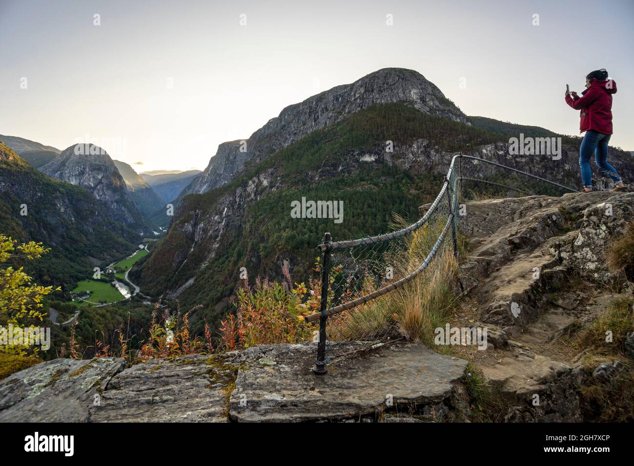 Junge Frau, die Landschaftsaufnahmen mit ihrem Smartphone in Stalheim, Norwegen, Europa macht Stockfoto