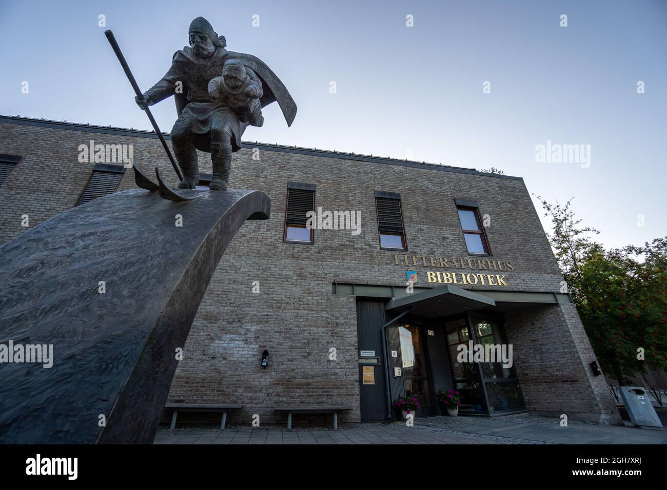 Bronzeskulptur eines Birkebeiner-Kriegers, der den bedrohten Prinzen Haakonsson vor der öffentlichen Bibliothek in Lillehammer, Norwegen, rettet Stockfoto