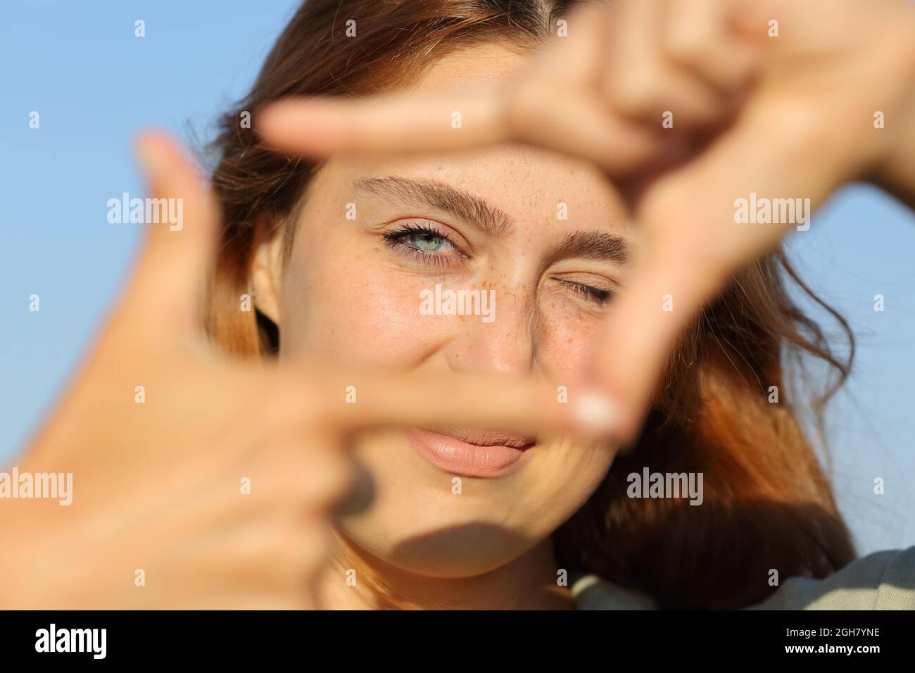 Frau, die mit den Händen umrahmt wurde und dabei die Kamera ansah Stockfoto