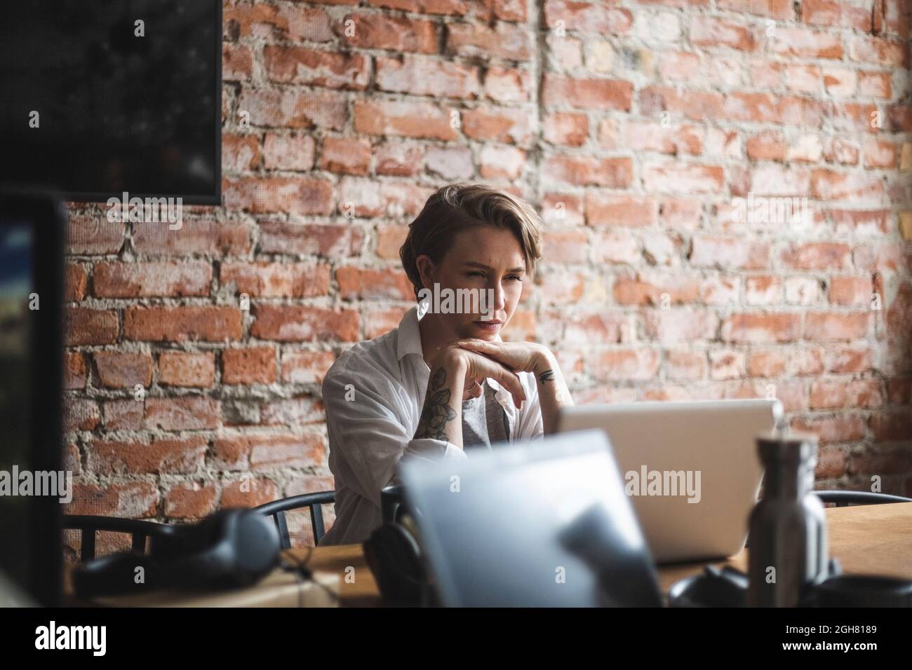 Hackerin, die im Kreativbüro am Laptop arbeitet Stockfoto