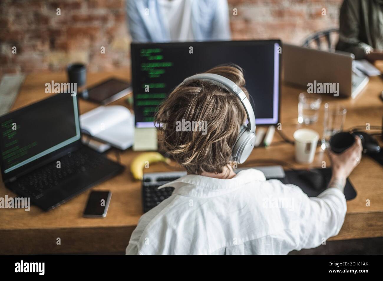 Hackerin, die im Kreativbüro am Computer arbeitet Stockfoto
