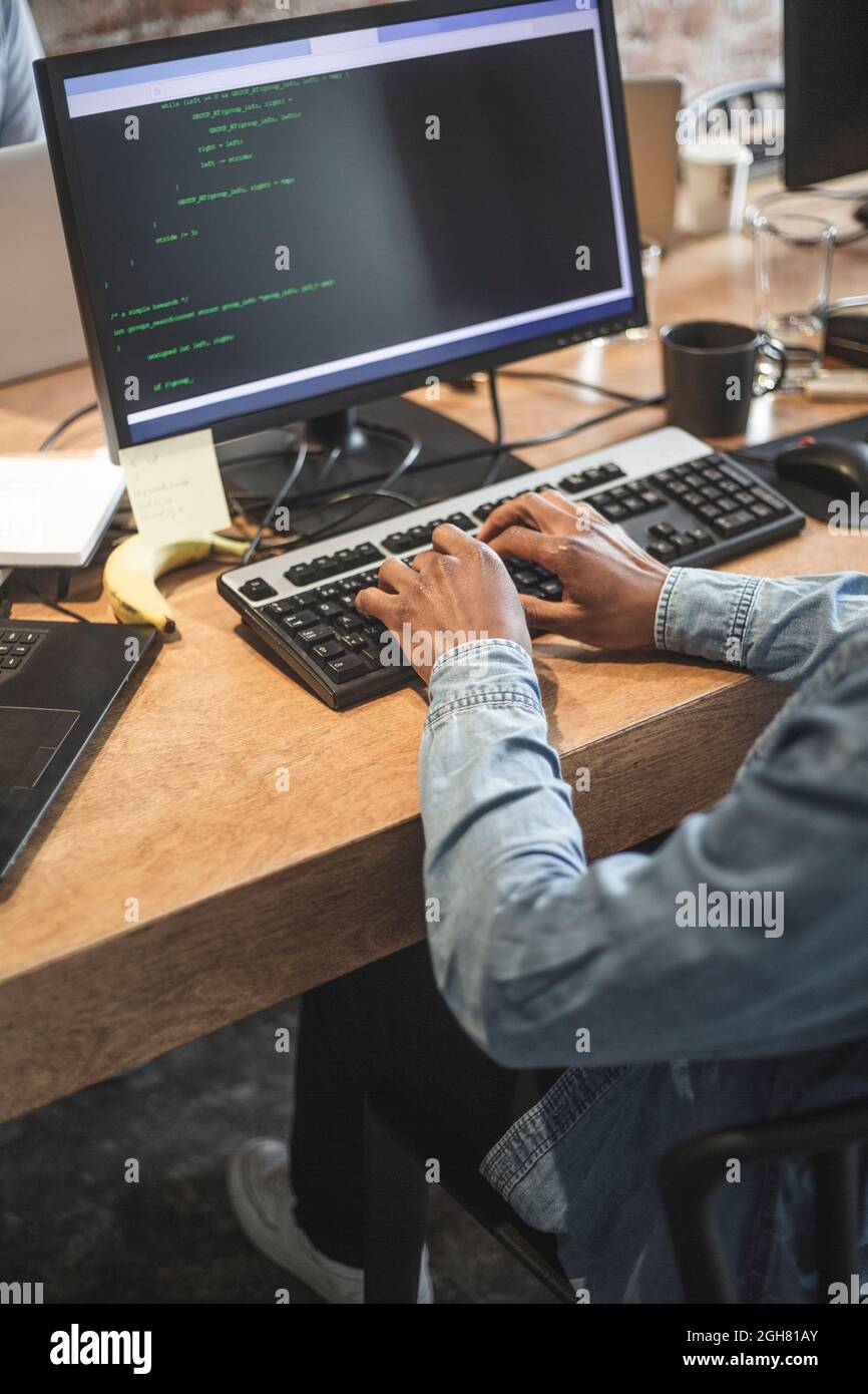 Mittelteil der männlichen Hacker-Codierung auf dem Computer im Büro Stockfoto