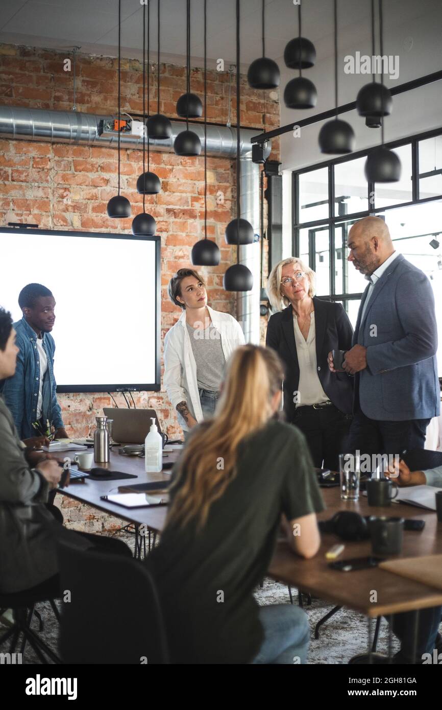 Weibliche und männliche Kollegen diskutieren im Büro über Geschäftsidee Stockfoto