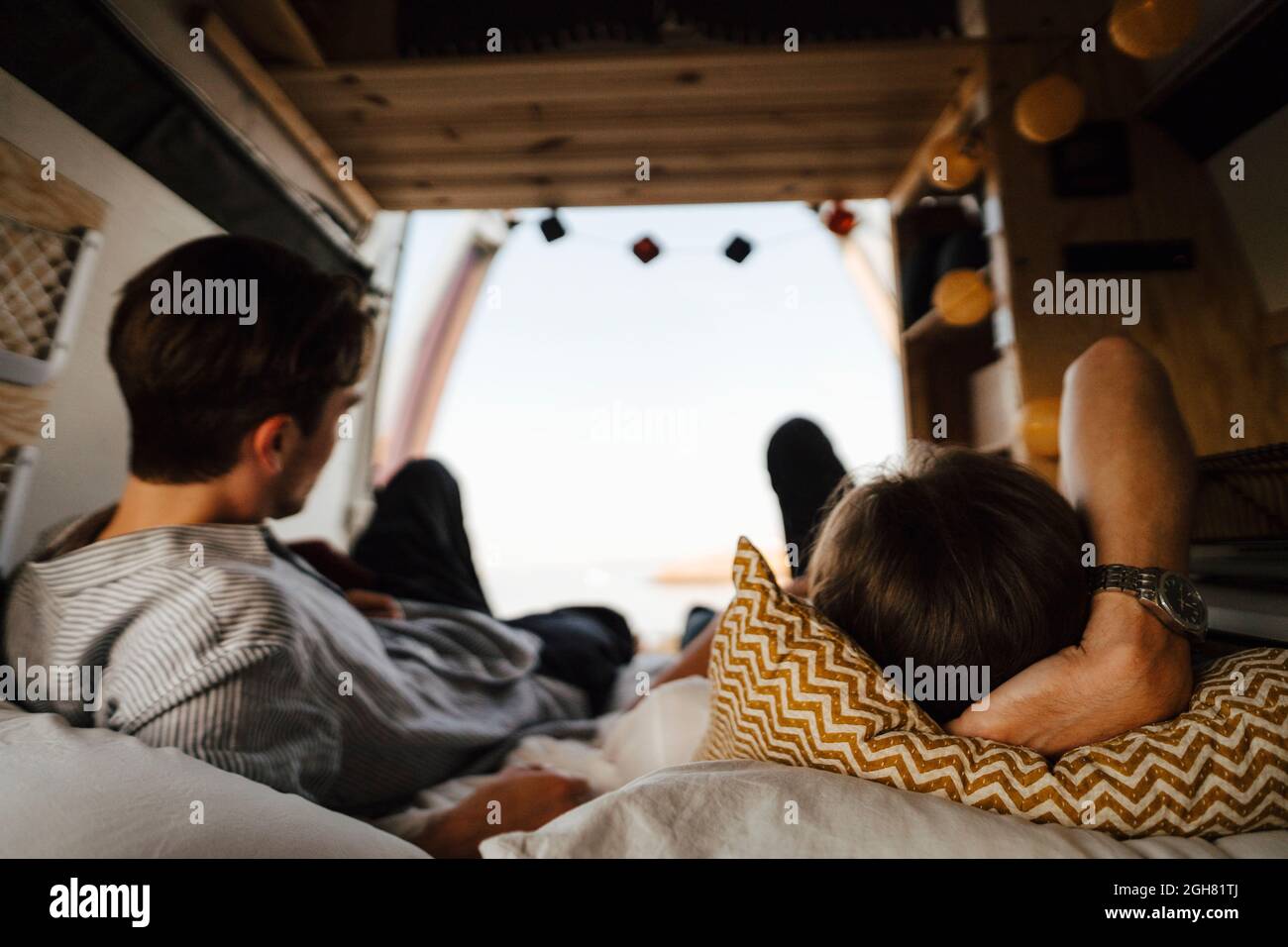 Männliche Freunde liegen im Campingbus auf dem Bett Stockfoto