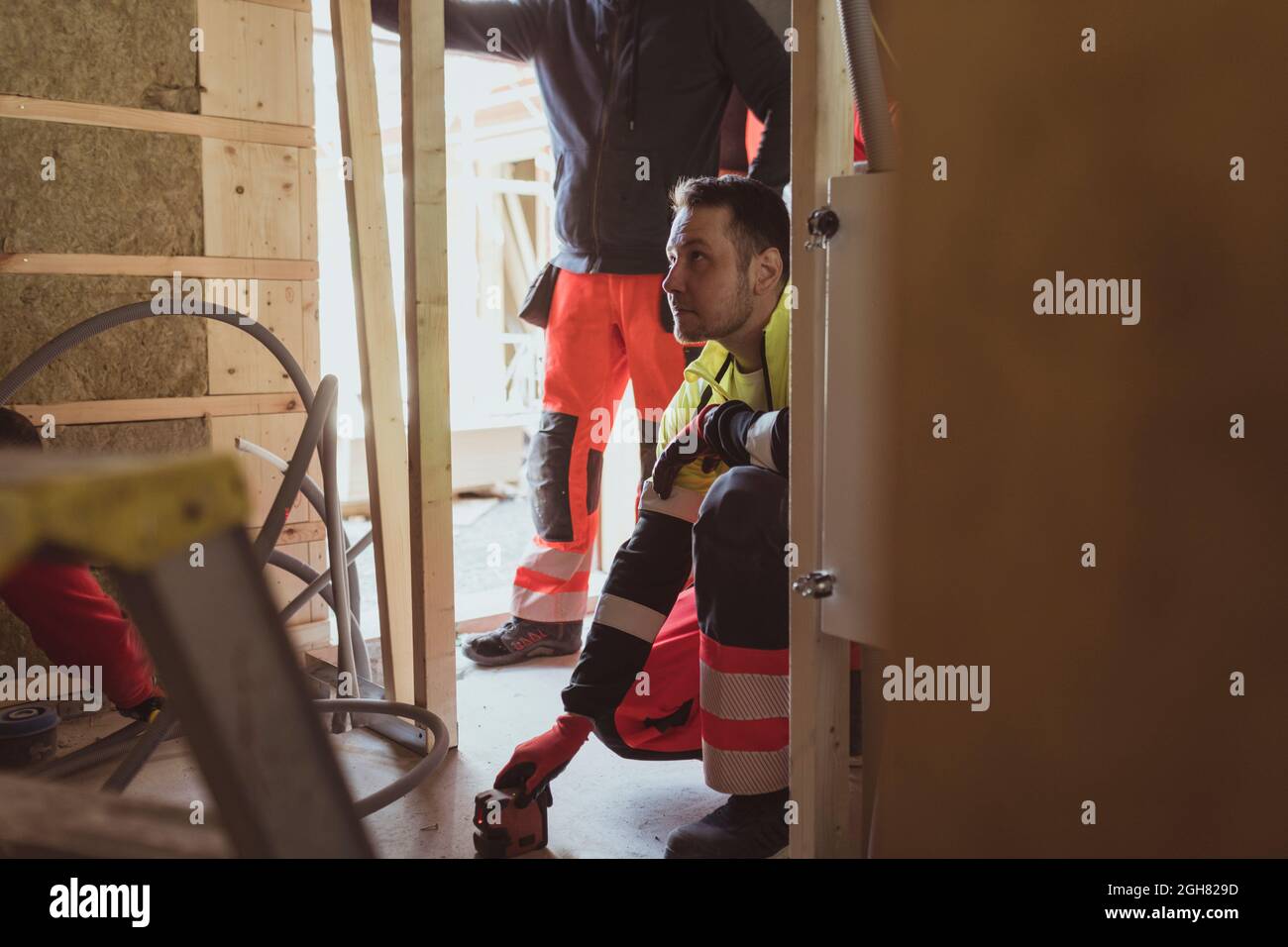 Männlicher Bauarbeiter mit Laserwerkzeug während der Arbeit auf der Baustelle Stockfoto
