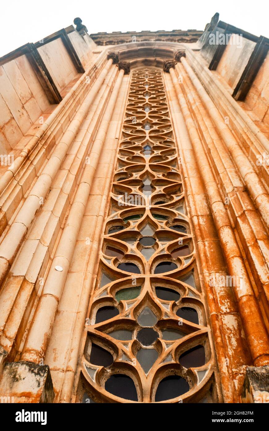Schönes geschnitztes Fensterdekor der gotischen mittelalterlichen Kirche mit langem Perspektivwinkel von unten - Vertikal, selektiver Fokus Stockfoto