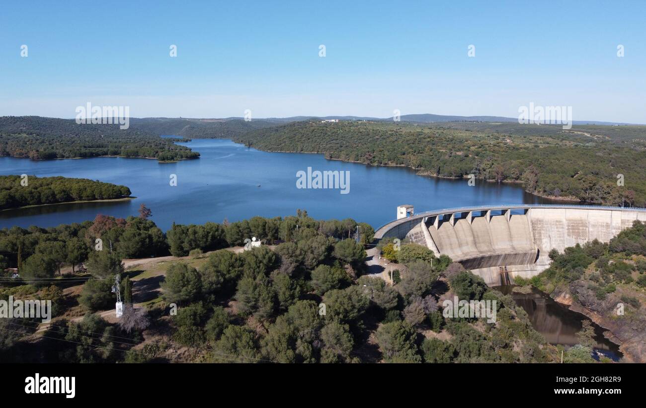 Staudamm von El Gergal, umgeben von viel Grün unter dem Sonnenlicht in Guillena, Spanien Stockfoto