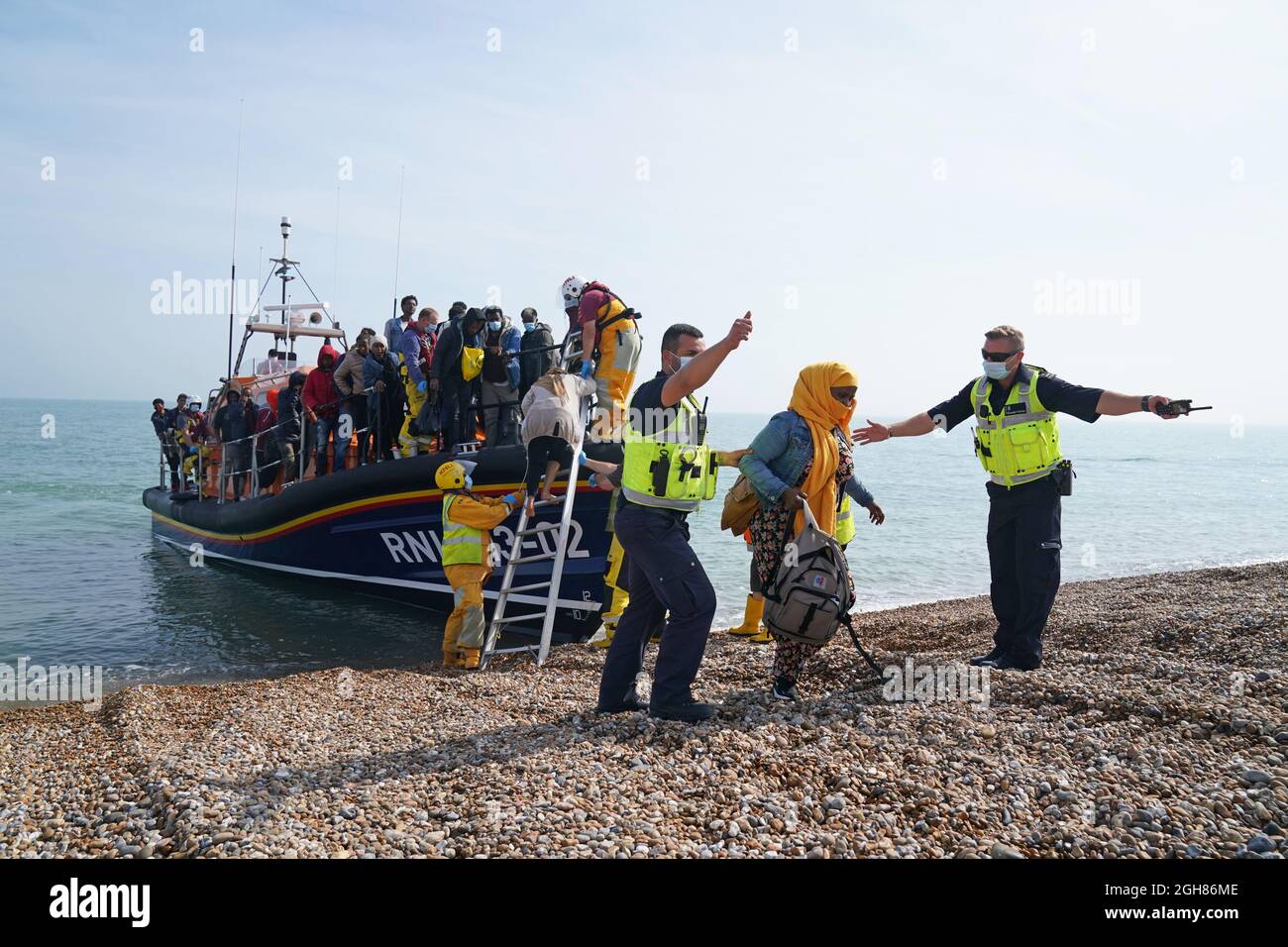 Eine Gruppe von Menschen, die als Migranten gelten, wird vom lokalen Rettungsboot in Dungeness in Kent an Land gebracht, nachdem sie nach einem Vorfall mit einem kleinen Boot im Kanal abgeholt wurde. Bilddatum: Montag, 6. September 2021. Stockfoto