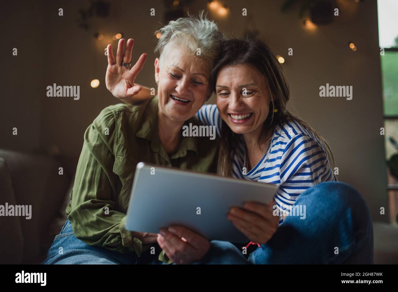 Porträt einer glücklichen älteren Mutter mit einer erwachsenen Tochter im Haus, mit Tablet. Stockfoto