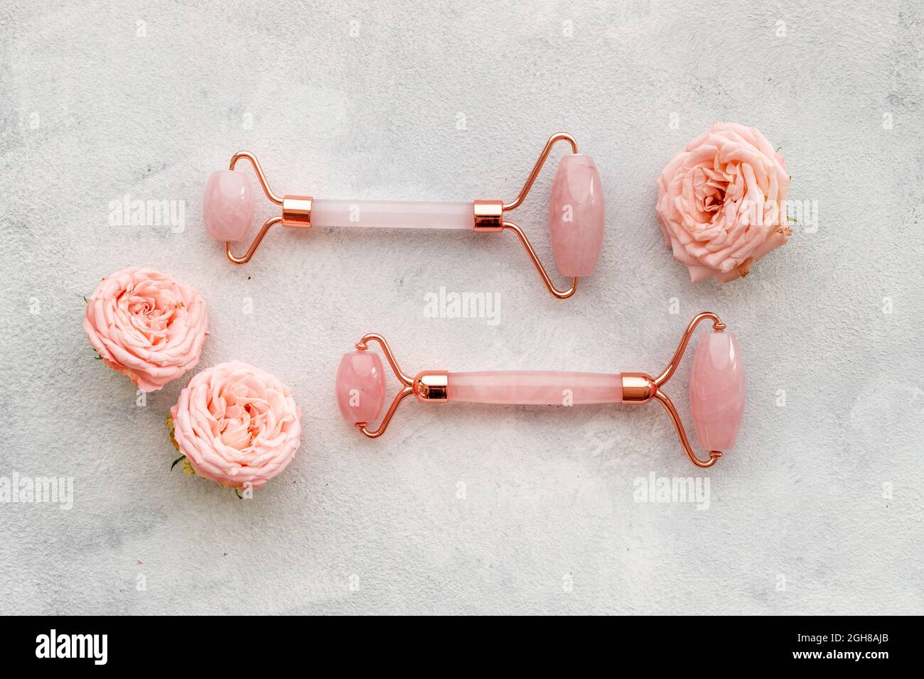 Massage Steinwalze mit Rosenblüten zum Anheben von Gesicht und Wellness Stockfoto