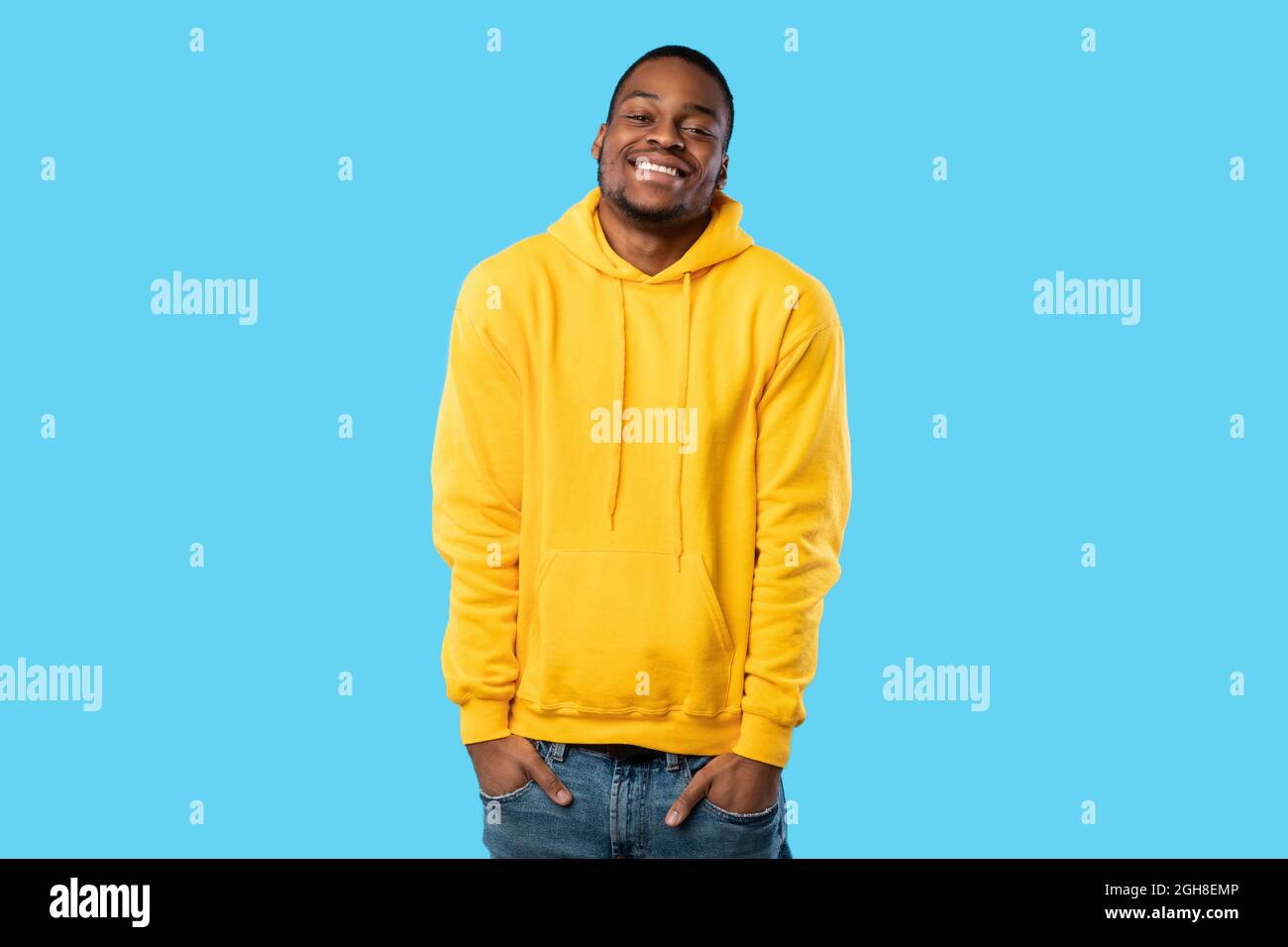 Happy African Guy Posiert Mit Händen In Den Taschen, Blauer Hintergrund Stockfoto