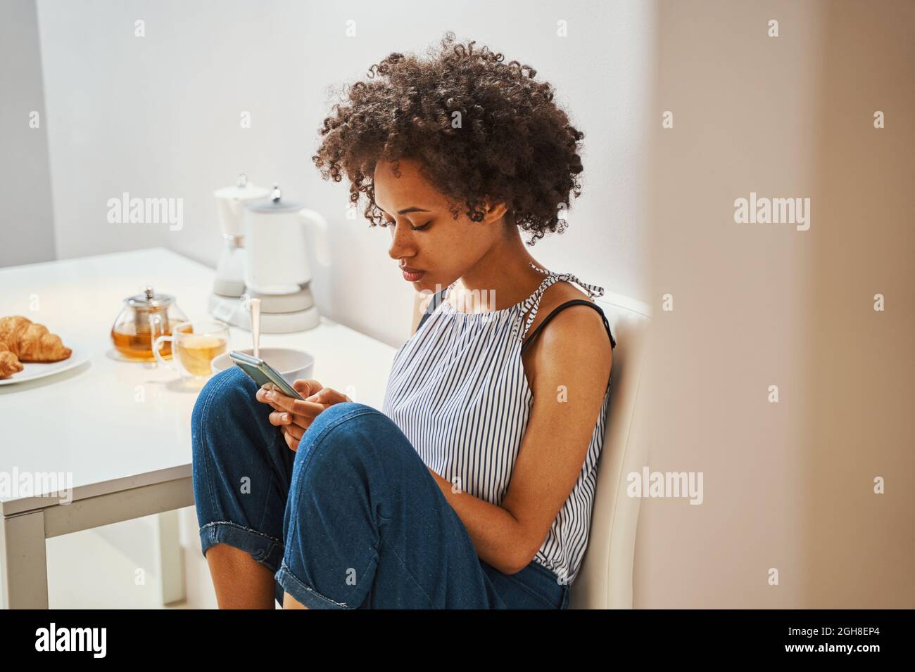 Frau, die beim Morgenessen mit ihrem Gadget im Internet surft Stockfoto