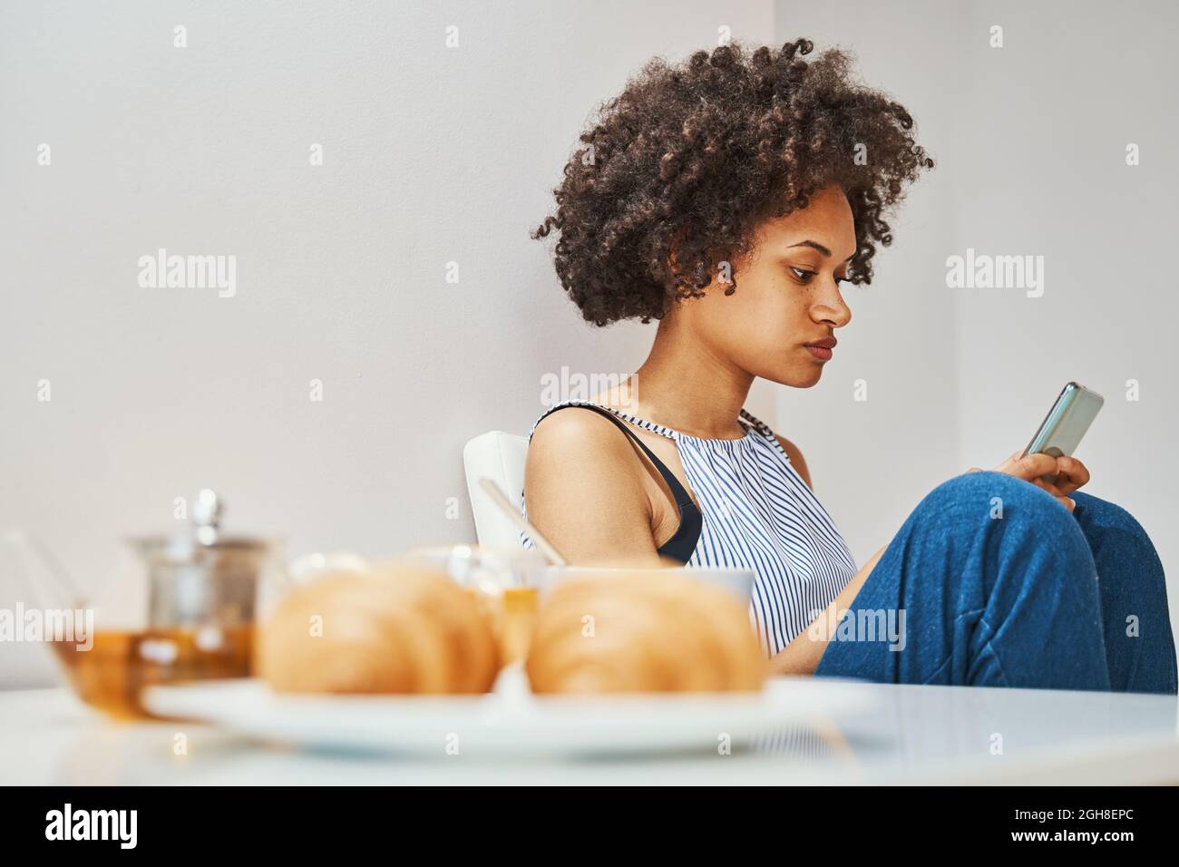 Frau konzentrierte sich beim Frühstück auf das Schreiben einer Textnachricht Stockfoto