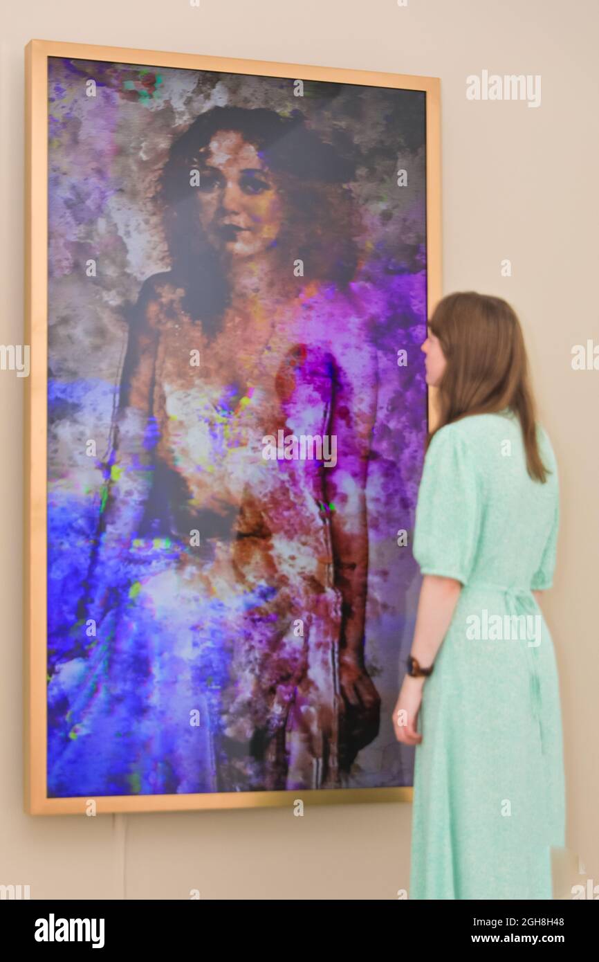 London, Großbritannien. September 2021. Ein Assistent posiert mit der Arbeit. Sommergäste: Rückwind Collective - ist eine Einzelausstellung, die eine einzigartige digitale Arbeit mit wechselnden Bildern präsentiert und NFT von der anonymen digitalen feministischen Kunstgruppe Rewind Collective begleitet. Rewind Collective ist ein digitales Künstlerkollektiv, dessen Aufgabe es ist, die Ungleichgewichte zwischen Geschlecht und Minderheiten in der gesamten Kunstwelt zu beseitigen. Kredit: Imageplotter/Alamy Live Nachrichten Stockfoto