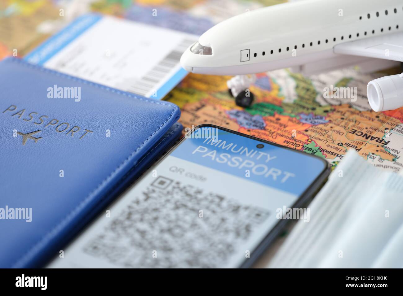 Auf dem Smartphone-Bildschirm Bescheinigung über die Immunität gegen Covid19 Flugticket und Reisepass auf dem Tisch Stockfoto