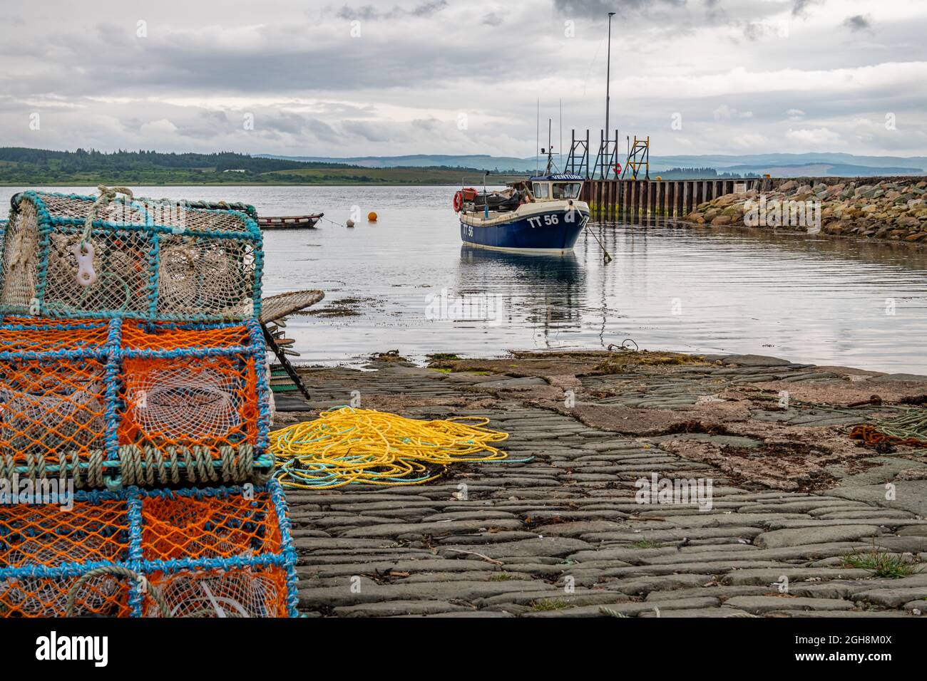 Fischerboot im Hafen von Ardrishaig mit Hummertöpfen im Vordergrund, Argyll und Bute, Schottland Stockfoto