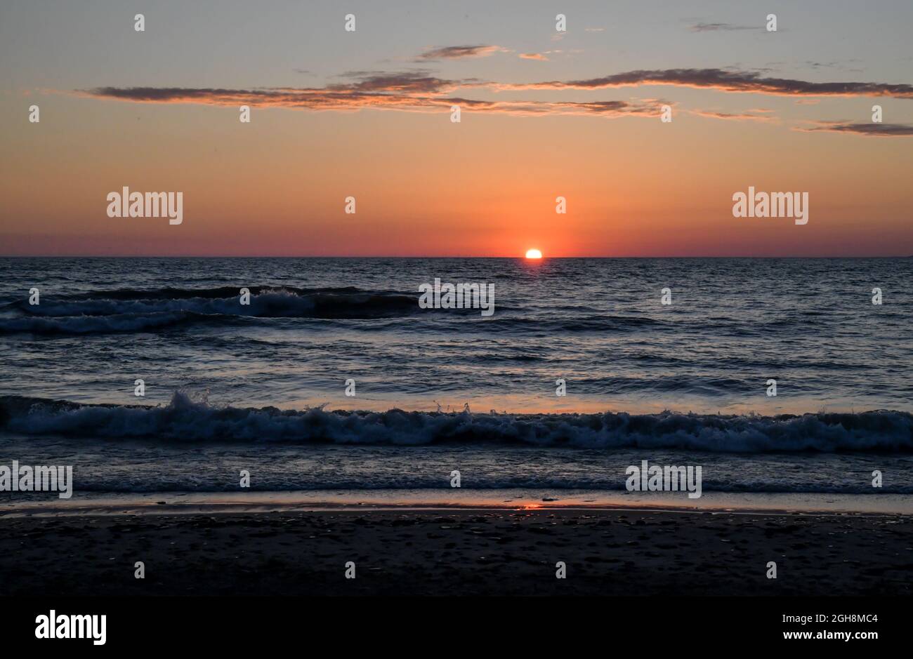 Farbenprächtiger Sonnenuntergang über dem Wasserhorizont am großen See Stockfoto