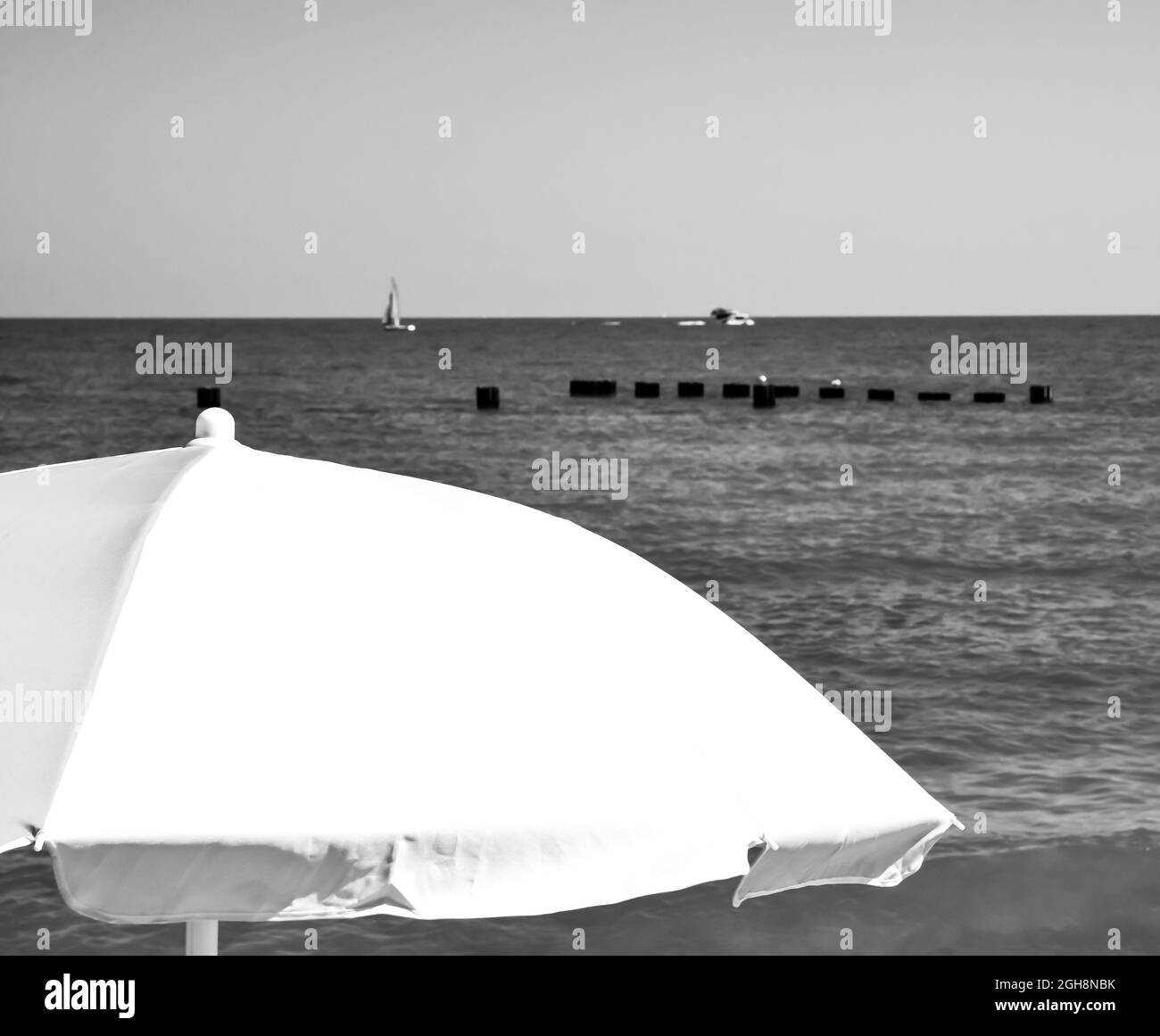 Farbenfroher Sonnenschirm vor blauem Sommerhimmel am Strand Stockfoto