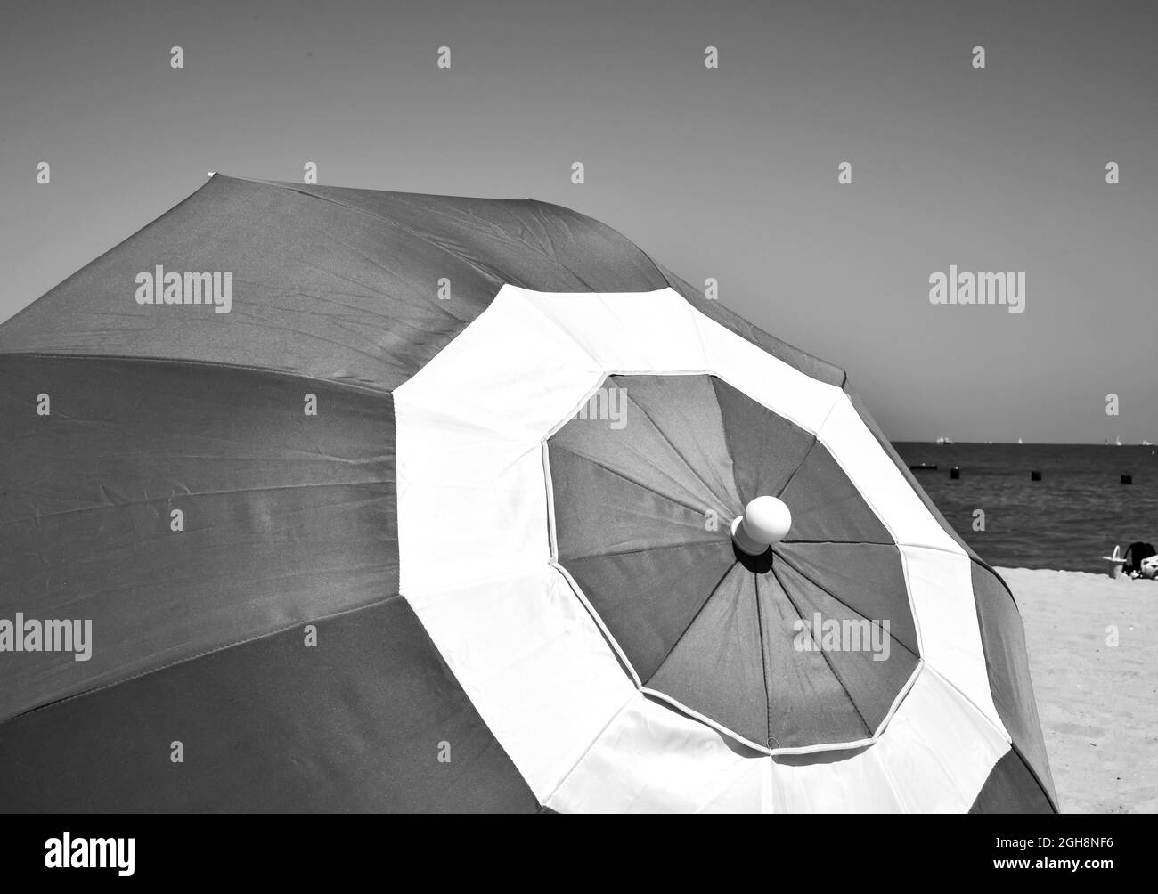 Farbenfroher Sonnenschirm vor blauem Sommerhimmel am Strand Stockfoto