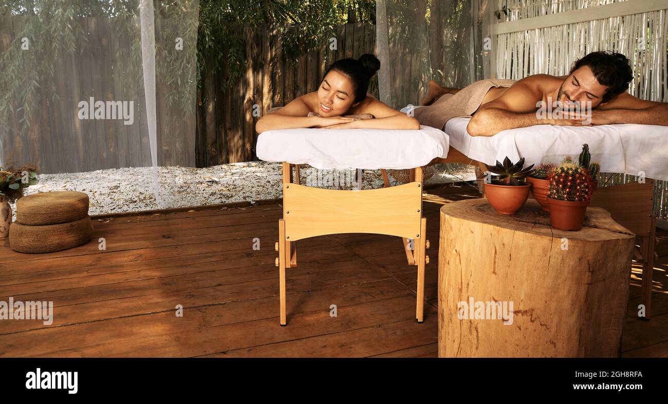 Schönes Paar während der Entspannung und Massage, gemeinsamen Tag im Wellness Bali Spa, im Freien. Gutaussehender Mann und asiatische Frau, die sich in einem exotischen Resort ausruhen Stockfoto